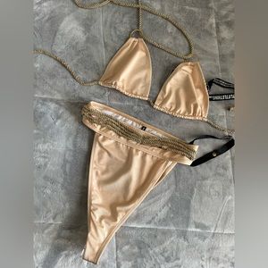 Nude with a hint of gold and rope like strings, bathing suit.